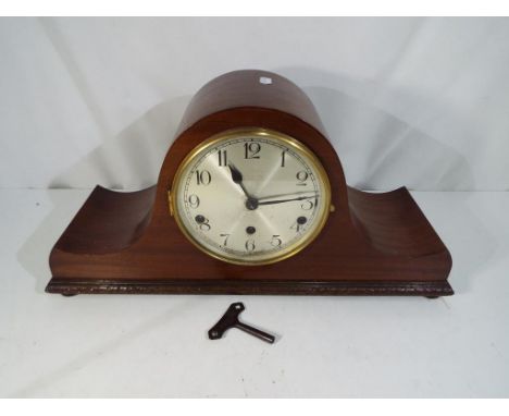 A Napoleon's hat mantle clock with carved detailing Arabic to a silvered dial movement marked Haller A.G. with key and pendul