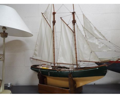 A large twin masted pond yacht of wooden construction approximately 110 cm [h] including masts, 100 cm bow to stern and 19 cm