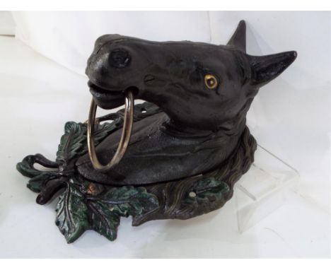 A large cast iron door knocker in a form of a horses head, approximately 28 cm x 19 cm x 15 cm, Est £20 - £40.