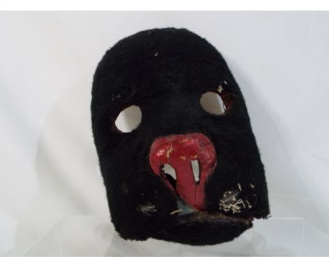 A vintage theatrical prop/mask depicting a cat, with fur lined exterior, metal teeth, hinged jaw and strap originally from th