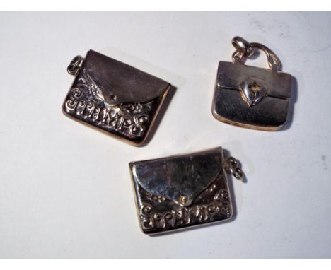 Three sterling silver stamp cases of which two styled in the form of envelopes, the other in the style of a handbag, all stam