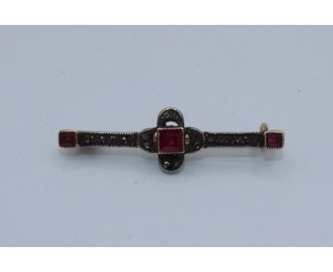 An Art Deco ruby and diamond brooch in original box. 3cm long