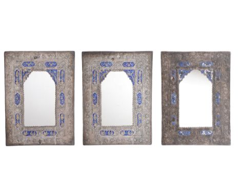  Three Indian silver coloured and enamel wall mirrors,   unmarked, chased with beaded, floral and foliate swag bands, chases 