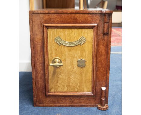 A vintage safe which has been overpainted and decorated in faux wood effect, with plaque 'Warranted Fireproof', with keys, he