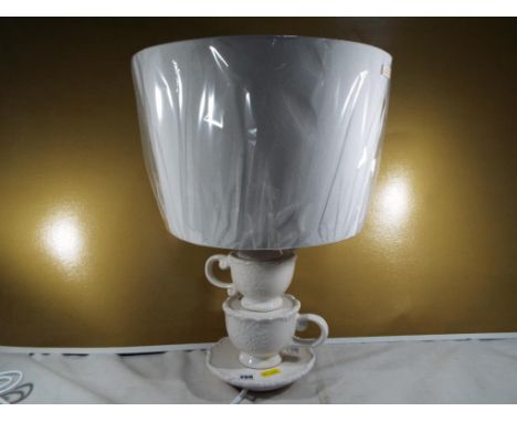 Unused retail stock - a good quality unused table lamp with an ivory coloured shade with unusual ceramic teacup stand