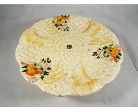 A Clarice Cliff cake plate decorated in the Celtic Harvest pattern signed to the base, 6.5 cm (h) x 20 cm (d). Estimate £30 -