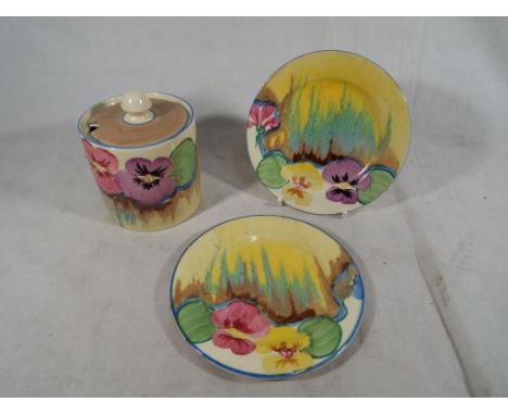 Clarice Cliff Pansies Delecia - a drum shaped preserve pot and cover hand painted with stylised flowers and foliage over a st