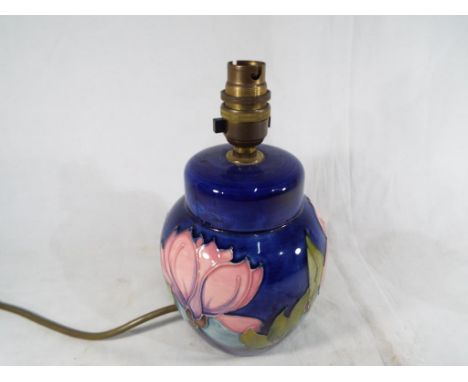 Moorcroft Pottery - a table lamp decorated with pink magnolia on a blue ground, 21 cm (h) Estimate £60 - £80