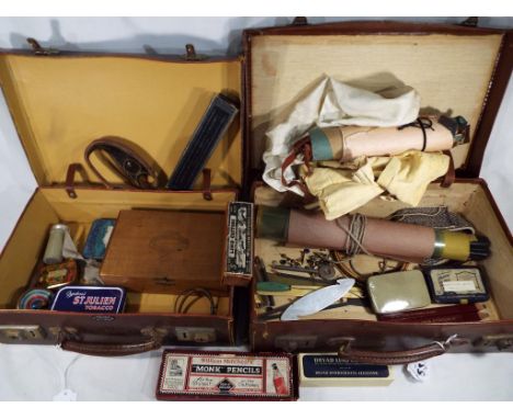 Two vintage suitcases containing a mixed lot to include vintage tins, cigar box, vintage spinning top, vintage tools for cutt