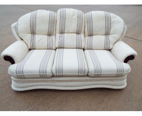 A good clean three piece suite comprising a three seater sofa and two armchairs upholstered in cream