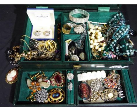 A vintage Racing Green jewellery box containing a quantity of vintage costume jewellery to include brooches, rings, necklaces