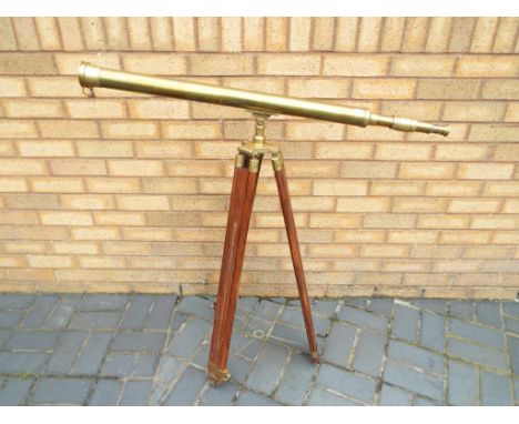 A large brass telescope on adjustable wood and brass tripod support, approximately 100 cm [h] x 100 cm [w], Est £60 - £100.