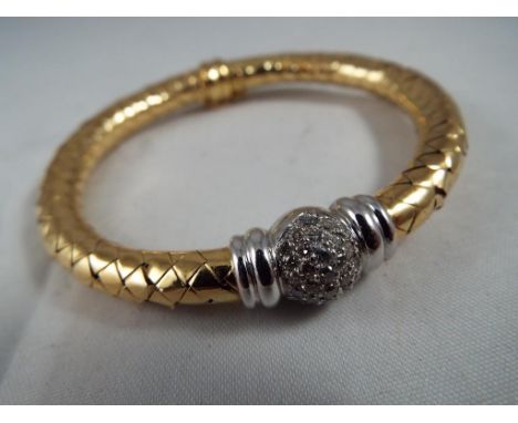 An 18kt yellow and white gold bangle with safety clasp and a stone set cluster approx weight 24.65 grams, internal circumfere