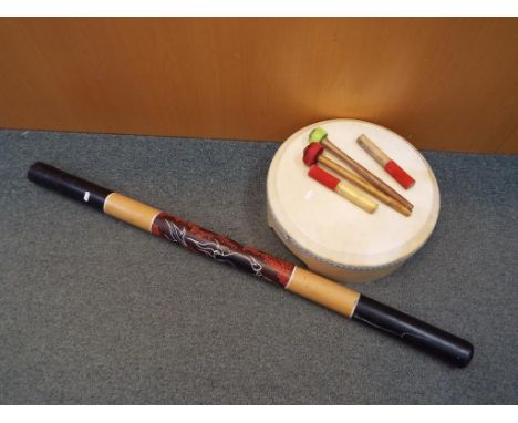 A didgeridoo with painted decoration approximately 119 cm (l) and a Bodhran style drum. (2)