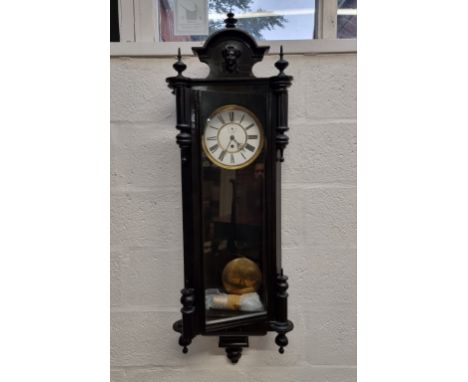 A late 19th century ebonized Vienna style wall clock,&nbsp;122cm high, with pendulum and weight.&nbsp; 