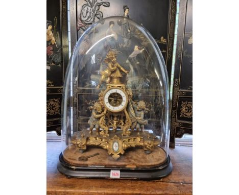 A late 19th century gilt spelter mantel clock, 39cm high, with pendulum, with ebonized stand and glass dome, total height 57c