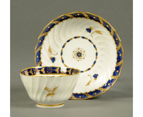 A Worcester fluted tea bowl, and near matching saucer, blue banding and gilt enrichments.