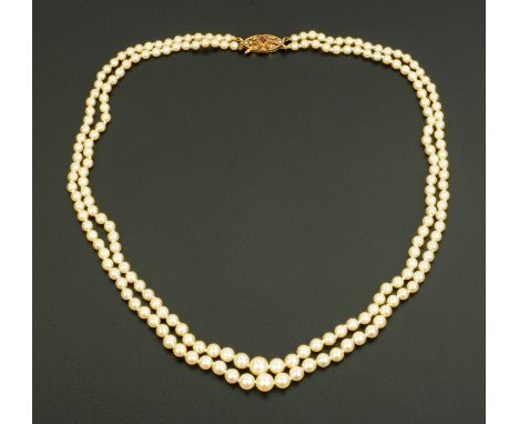 A pearl (possibly natural) necklace, two strand, with 9 ct gold clasp set with a ruby and seed pearls London hallmark 1965.  
