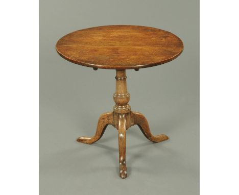 A George III oak tripod table, with snap action, turned centre column and three downswept legs terminating in pad feet.  Diam