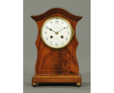 An Edwardian inlaid mahogany mantle clock, by E. Scanlan, Preston, with two-train striking movement, the case raised on brass