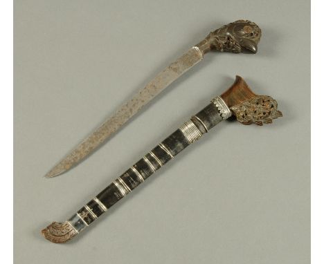 A Celanese dagger, with carved horn handle and scabbard with silver coloured metal bands, 19th century.  Length 39 cm (see il