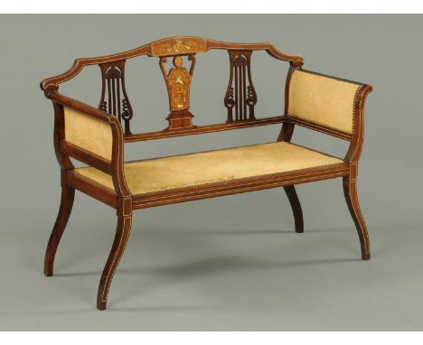 An Edwardian inlaid mahogany small settee, the back with pierced splats, the seat and arms upholstered in a foliate patterned