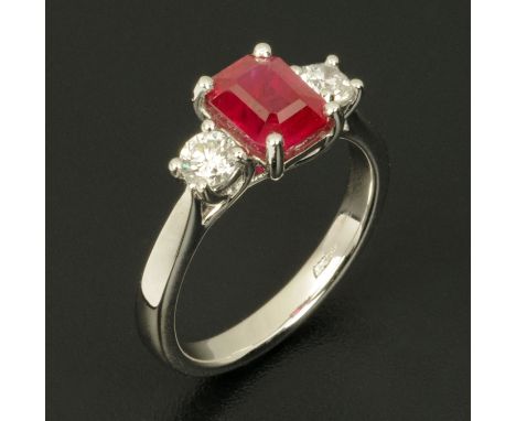 An 18 ct white gold emerald cut Burmese ruby and diamond three stone ring, ruby approximately 1.9 carats, diamonds .4 carats,