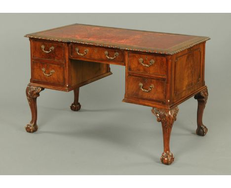 An Edwardian mahogany inverted breakfront desk, with tooled leather writing surface and fitted with five drawers with brass d