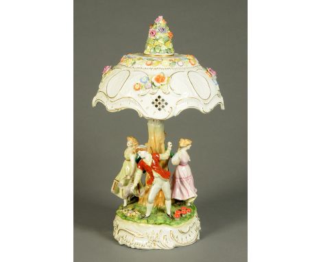 A Continental porcelain table lamp, with canopy above a series of dancing figures, floral encrusted and polychrome.  Height 6