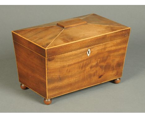 A George III mahogany tea caddy, boxwood strung, sarcophagus form and with three interior compartments, raised on ball feet. 