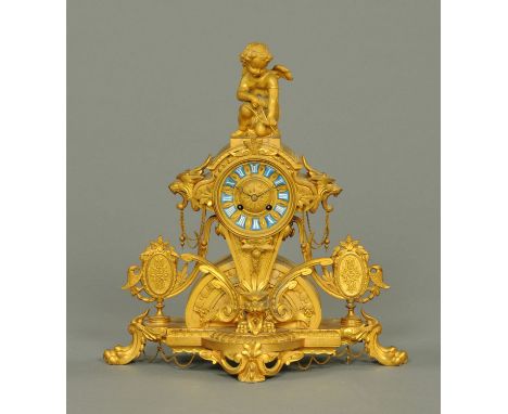 A French gilt metal mantle clock, with Cupid mount and with blue porcelain tablets with Roman numerals to the circular dial. 
