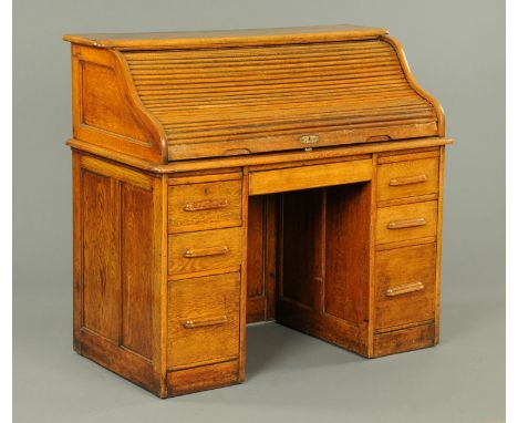 A late Victorian oak roll topped desk, with fitted interior and series of drawers to each pedestal.  Width 121 cm.  CONDITION