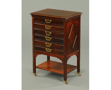 An Edwardian mahogany music cabinet, with six fall front drawers and shelf and raised on legs of moulded section terminating 