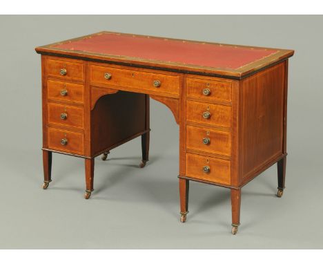 An Edwardian inlaid mahogany kneehole desk, fitted with a kneehole drawer and four further drawers to either side and raised 