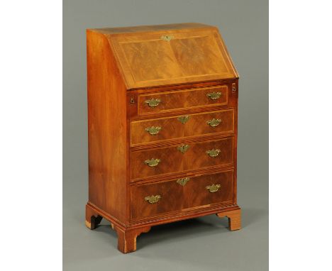 A walnut veneered bureau, in the Queen Anne style, with slope front to fitted interior above four graduated drawers with bras