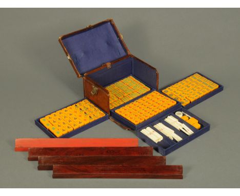 A mahjong set, in leather case, 144 tablets, and four rosewood tile holders.  Case width 23 cm.  CONDITION REPORT: The stands