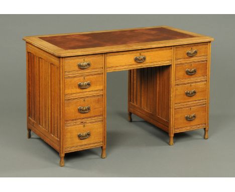 An Edwardian oak desk, fitted with a kneehole drawer and four further drawers to either side and raised on short legs.  Width