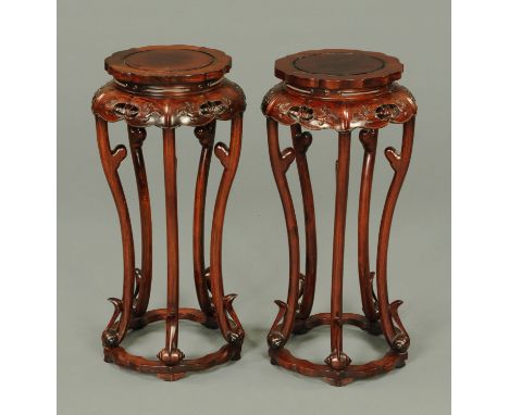 A pair of Chinese hardwood jardiniere stands, shaped circular outline, each with pierced frieze and raised on five scroll leg