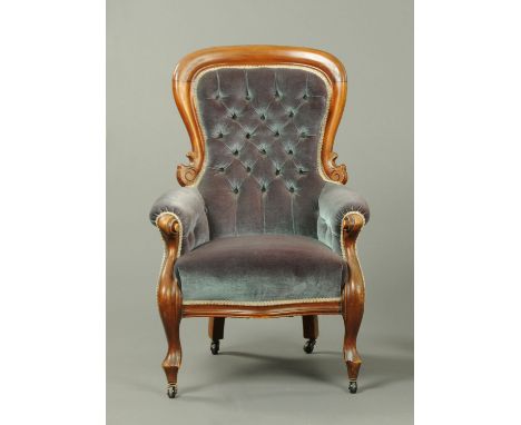 A Victorian mahogany armchair, with simple moulded exposed showframe, upholstered in deep buttoned blue velvet and raised on 