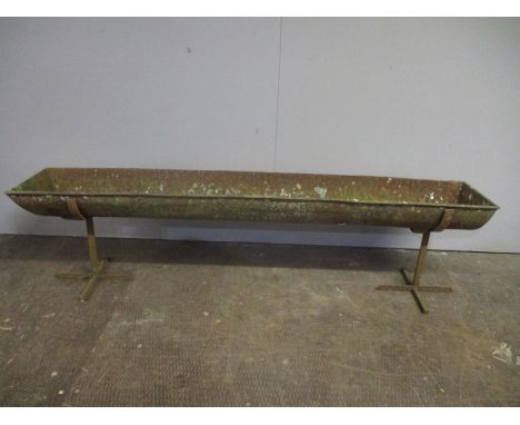 A cast iron feeding trough/planter on stands, length 152cm.
