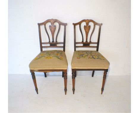 A pair of Edwardian inlaid mahogany chairs, with tapestry seats.