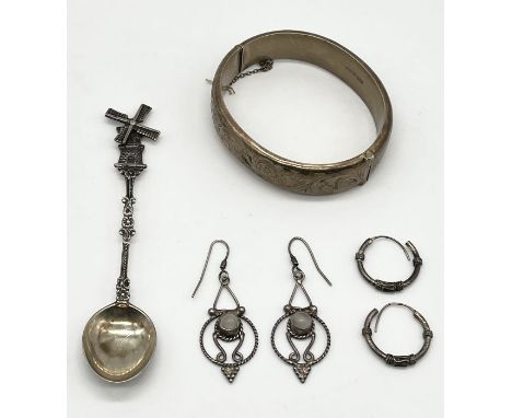 A hallmarked silver bangle along with two pairs of silver earrings and a continental silver spoon