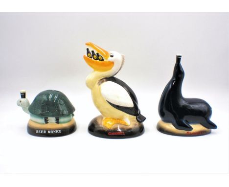 Three reproduction Guinness ceramic money boxes in the form of a pelican, seal and a tortoise.
