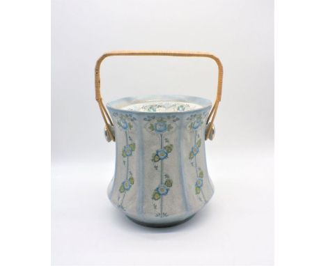 A ceramic slop pail, with wicker handle.