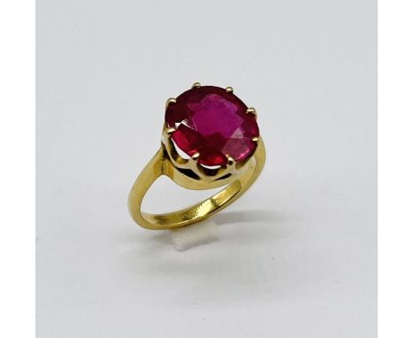 An unmarked gold (tested 14ct) "doll" ring set with a ruby measuring approx. 0.9cm diameter