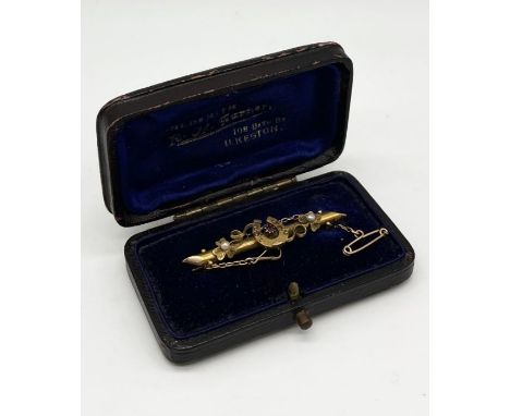 A cased 15ct gold brooch set with a ruby and seed pearls, weight 3.2g