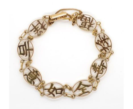 Oriental gold bracelet with panels of open work Chinese characters. With ladder clasps and safety chain Marked 14k 585 approx