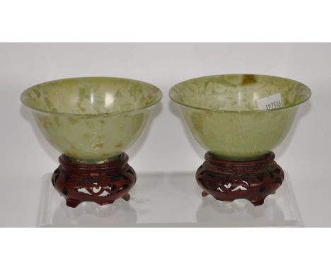 Pair Chinese jade rice bowls &amp; stands each bowl on a carved wood stand, (diameter 10cm approx, each).