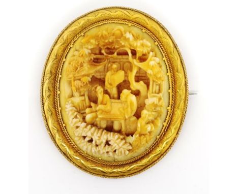 Antique Chinese carved ivory and gold brooch with a well carved central panel set in a engraved yellow gold border with appli