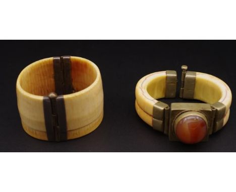 Two Ivory bangles circa 1950s both with split pin catches. One set with banded agate. A/F to one of the clasps This item may 